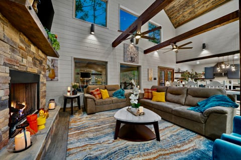 Spacious, cozy living room with tall ceilings and a warm fireplace — perfect for family gatherings.