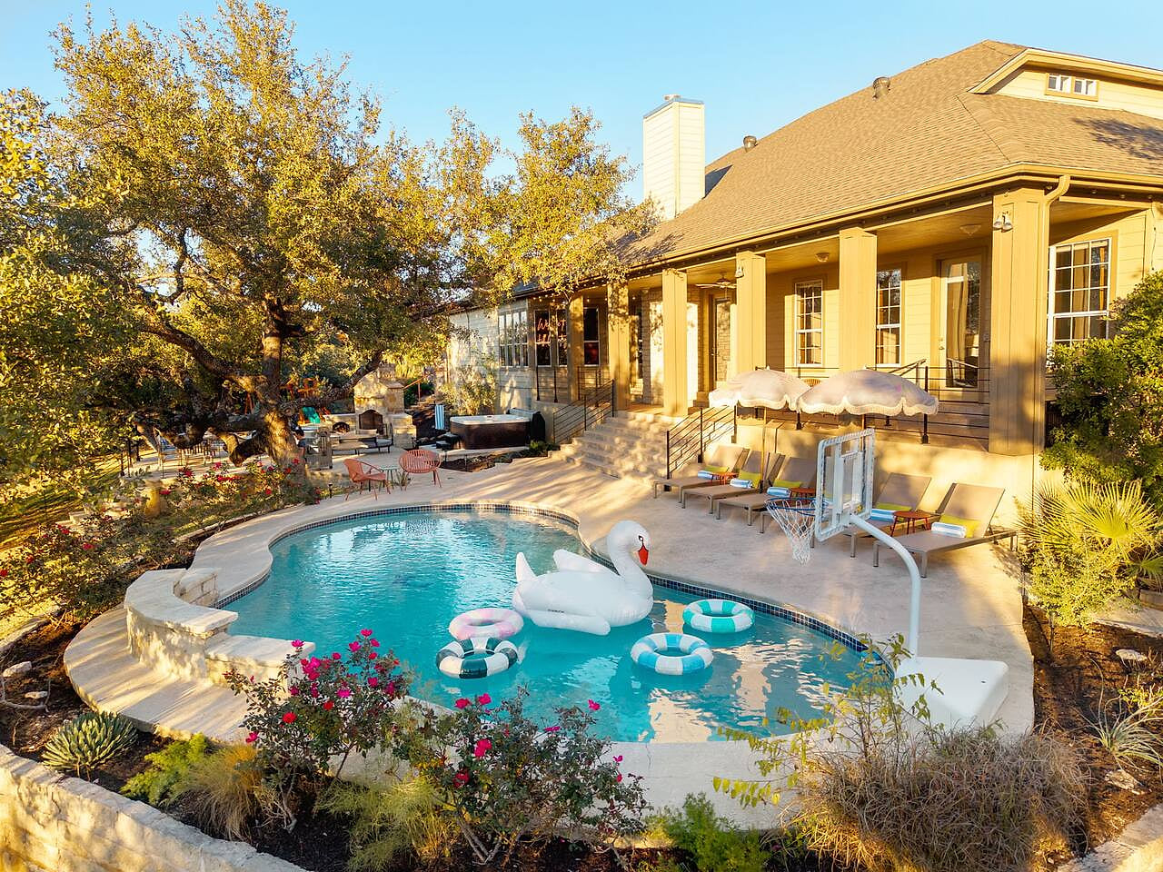 Pool with pool loungers, hot tub, outdoor dining patio, and covered patio.