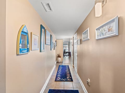 Bright, art-filled entry hall with tiled floors and a welcoming coastal feel