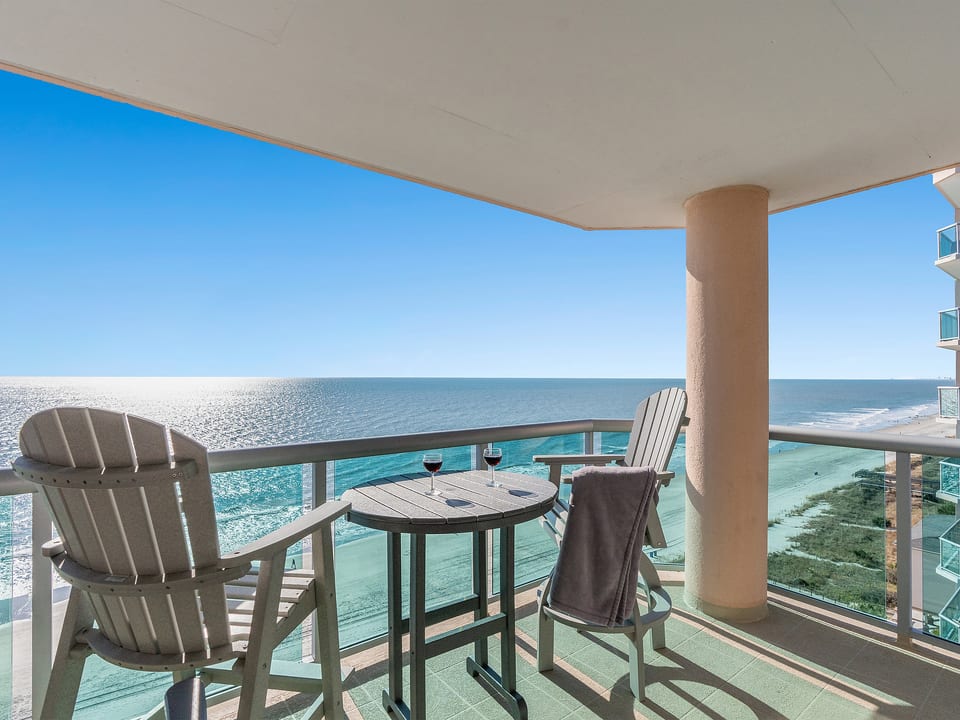 Private oceanfront balcony with panoramic beach views and sunset seating