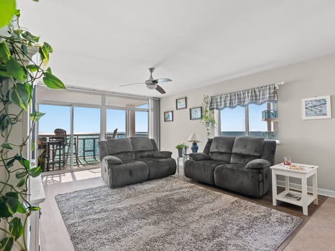 Bright coastal living room with plush seating and ocean-view balcony