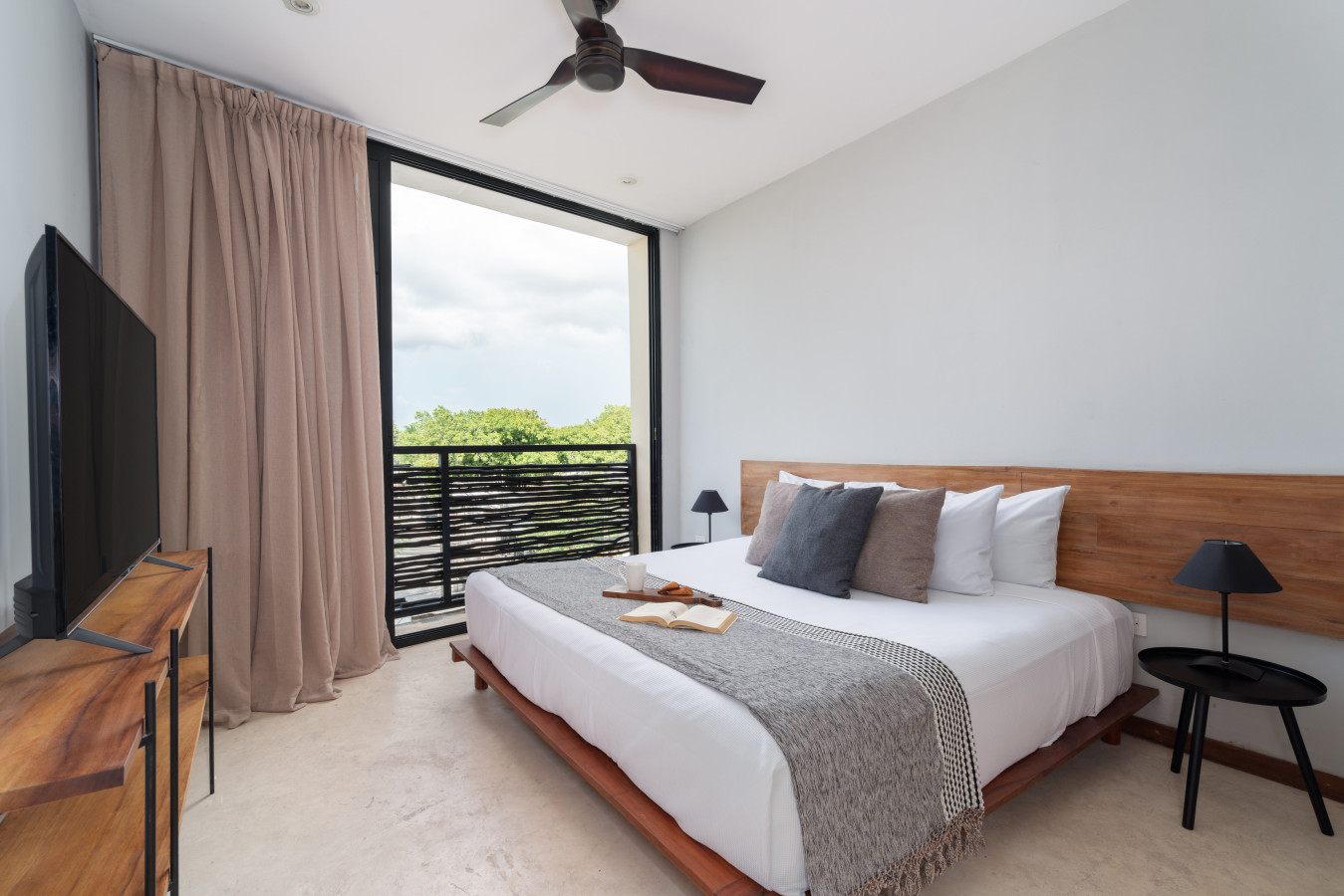 This airy bedroom features a king bed, large windows, and serene views, creating an ideal retreat to relax, recharge, and enjoy a calm, comfortable stay.