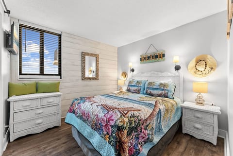 Cozy coastal bedroom with queen bed, warm lighting, and beach-inspired décor.