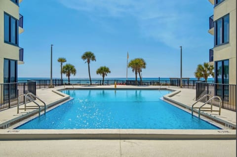 Gulf-front pool with lounge chairs and blue water views—perfect for relaxing in the sun.