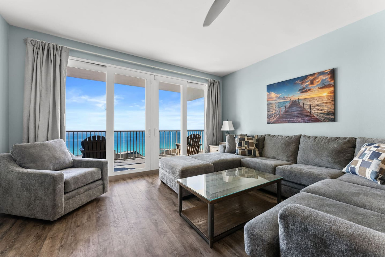 Spacious living room with plush sectional seating and floor-to-ceiling Gulf views for the perfect beach retreat.