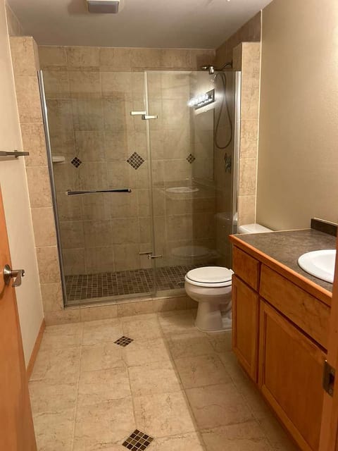 Spacious bath with glass walk-in shower, tile accents, and stone vanity
