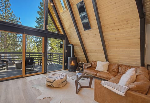 A-frame lounge with forest views, floor-to-ceiling glass, and deck.