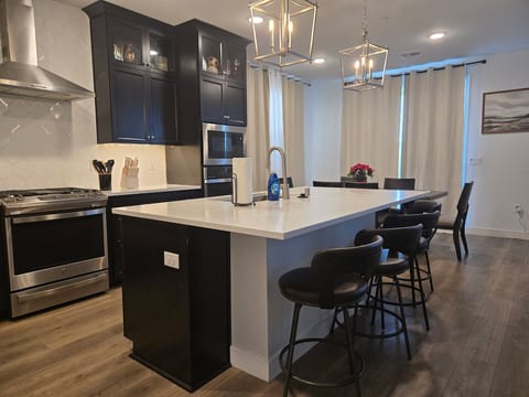 Beautiful, modern kitchen with stainless steel appliances large island and dining room Table.