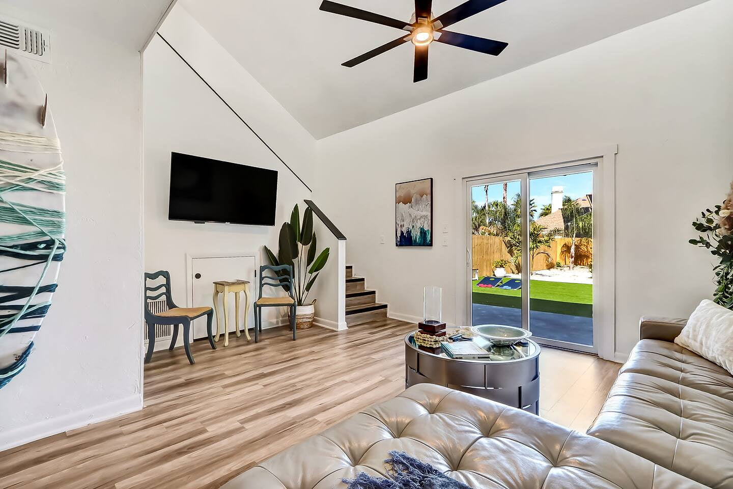 A bright, stylish living space with vaulted ceilings and seamless indoor-outdoor flow. The perfect spot to unwind after a beach day or enjoy movie nights with the fam.