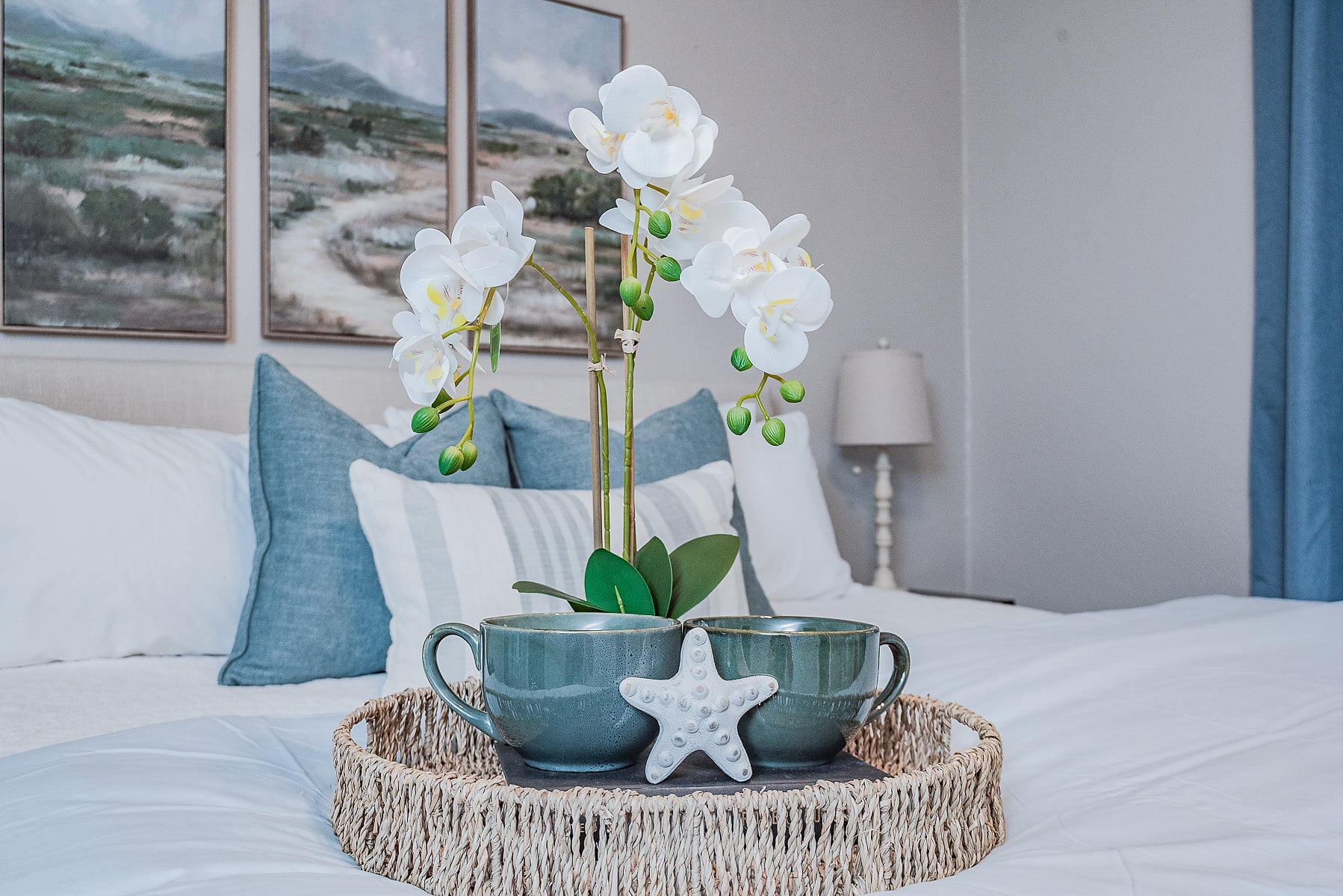 Serene coastal bedroom with crisp linens and orchid welcome tray.