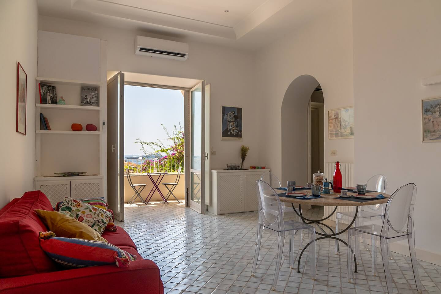 Bright and stylish living space with sea-view doors opening onto a private terrace. Featuring cozy seating, Mediterranean décor, and a serene atmosphere, it’s the perfect spot to relax after exploring the beauty of Capri.