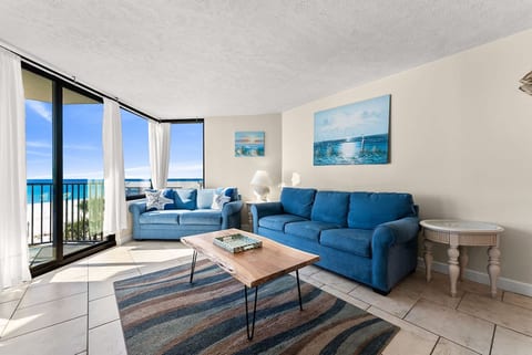 Spacious living room with a queen-size sleeper sofa, Gulf views, natural light, and direct balcony access.