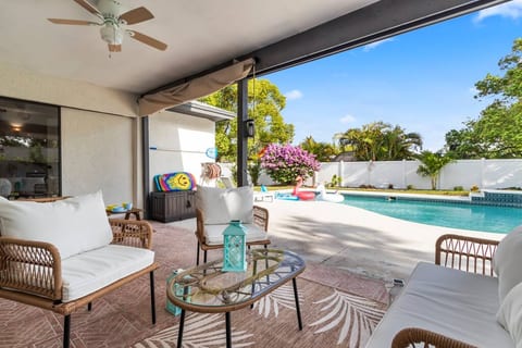 The adults enjoy a relaxed conversation, occasionally glancing over at the children, full of energy and enthusiasm, are happily engaged in their playful activities in the pool.