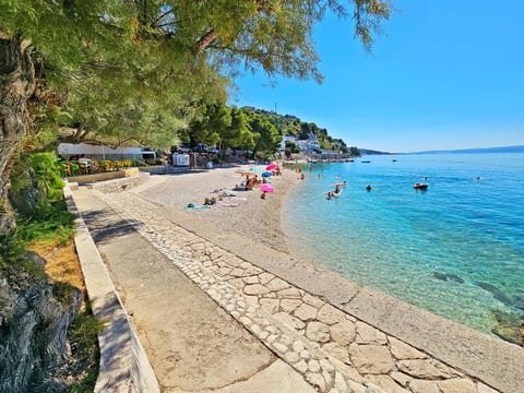 mit überdachter Terrasse und Balkon am Strand mit Meerblick