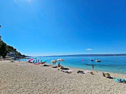 mit überdachter Terrasse und Balkon am Strand mit Meerblick