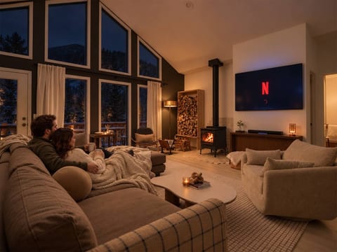 Cozy up for some Netflix and chill in a beautifully designed living room with floor-to-ceiling windows that frame the rugged beauty of the Rockies.