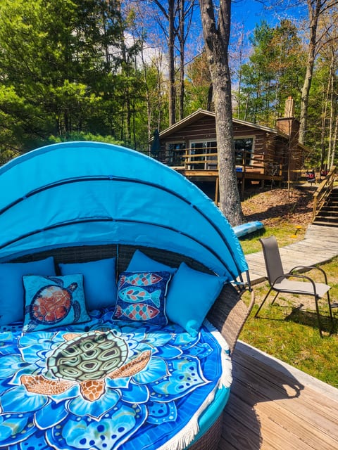This colorful outdoor daybed offers a comfy place to unwind just steps from the cabin. Surrounded by tall pines and woodland views, it’s a guest favorite for soaking up sunshine or afternoon naps by the lake.