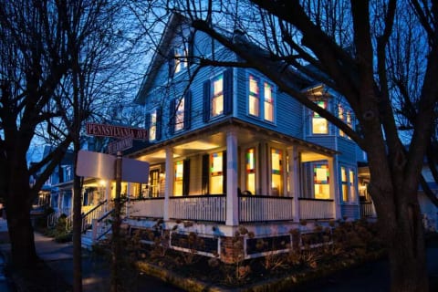 Chadwick Cottage Vacation Rental Home. Exterior at night showing Queen Anne Stained Glass Windows. Vacation Rentals Asbury Park. Vacation Rentals Ocean Grove.
