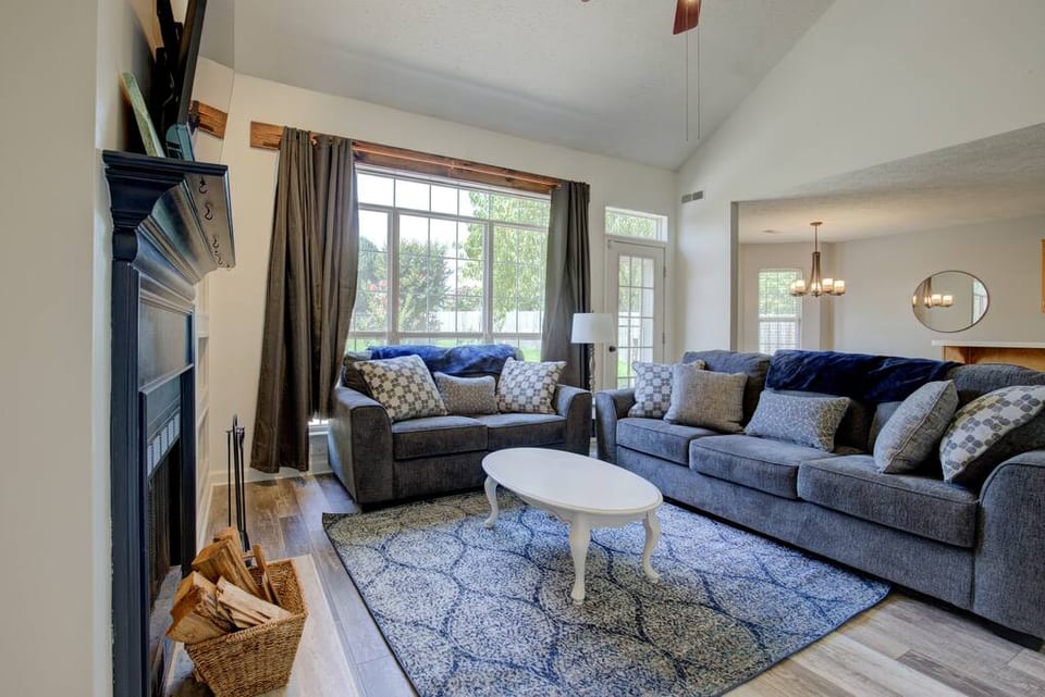Relax and create memories in the tall-ceilinged living room that overlooks the beauty of the backyard