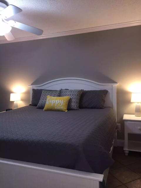 King bed in master with 3 inch memory foam topper. Extra blankets, pillows, down alternative comforter, room darkening curtains, ceiling and stand fan, USB ports and electric charging on one nightstand, plus alarm clock. All bed items are zipper-encased for extra cleanliness.