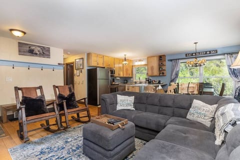 Great room with comfortable modular sofa, dining table and kitchen