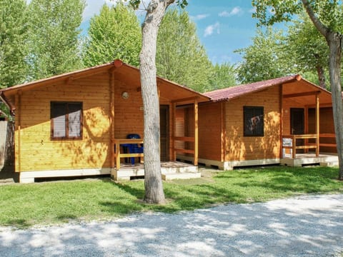 Bungalow aus Holz mit Veranda und nah am Strand.