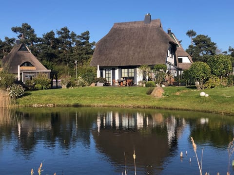 Reetdachhaus am Wasser mit Sauna, Außenwhirlpool, Kamin und E-Ladestation