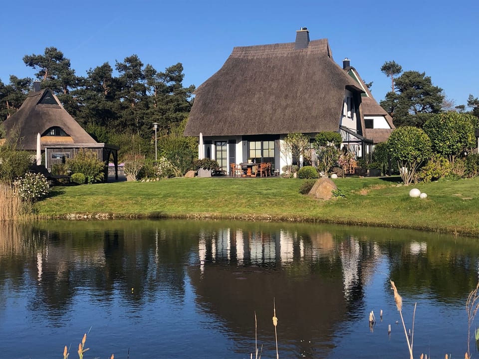 Reetdachhaus am Wasser mit Sauna, Außenwhirlpool, Kamin und E-Ladestation - Fuhlendorf