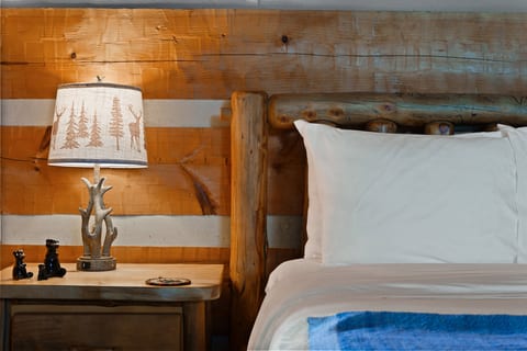 Rest easy in the queen bed at Nestled Oaks, where handcrafted log furnishings bring true Smoky Mountain charm.