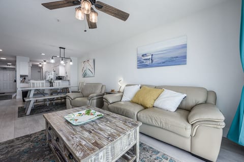 Living Room with Breathtaking Views Relax in this stylish living area, featuring plush seating, coastal decor, and a large flat-screen TV. The sliding glass doors lead to your private balcony,