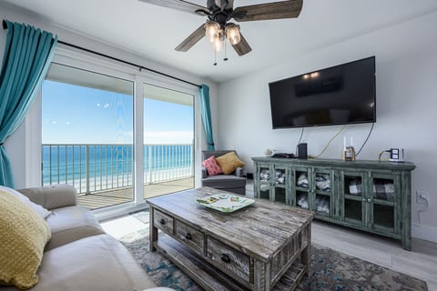 Living Room with Breathtaking Views Relax in this stylish living area, featuring plush seating, coastal decor, and a large flat-screen TV. The sliding glass doors lead to your private balcony,