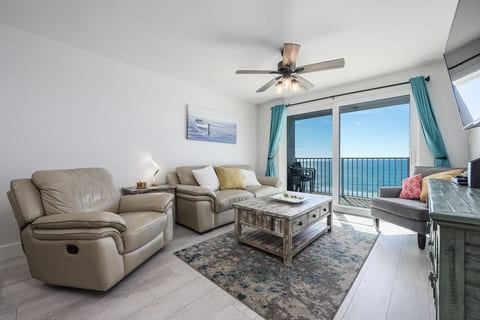 Living Room with Breathtaking Views Relax in this stylish living area, featuring plush seating, coastal decor, and a large flat-screen TV. The sliding glass doors lead to your private balcony,