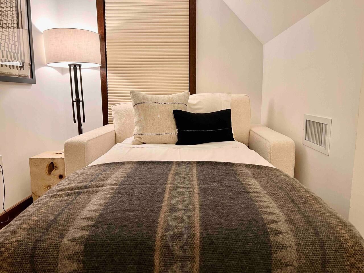Twin size sleeper sofa next to bed in bedroom.