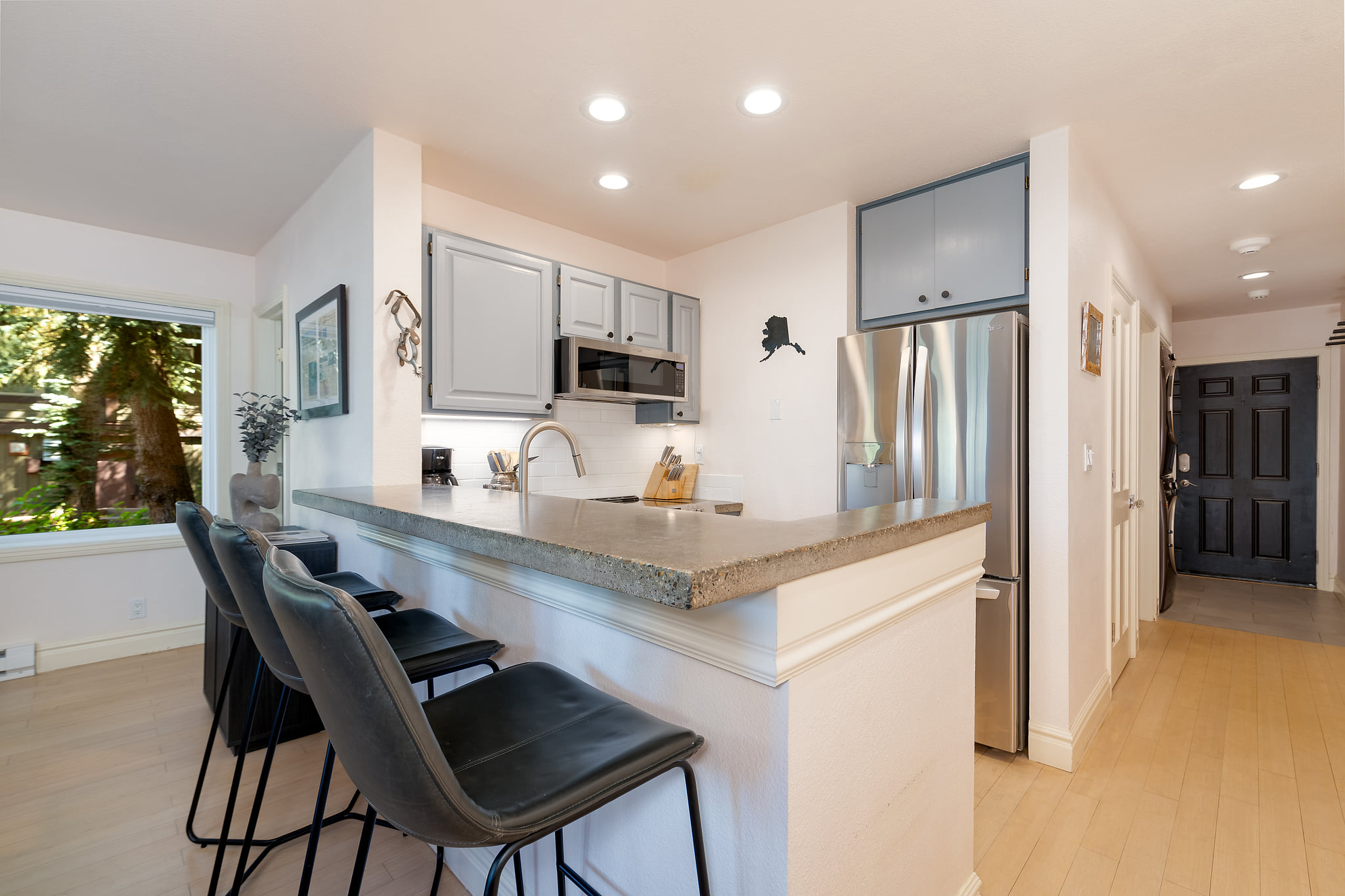 Bright modern kitchen with breakfast bar and stainless steel appliances