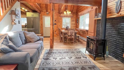 Living room area has a love seat and sofa with television and propane fireplace