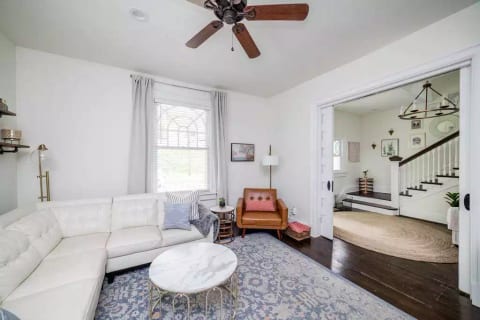 Large living room into airy foyer. 6 seat sectional and original pocket doors