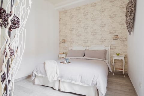 The room is harmonious and welcoming, the upholstery of the bottom is vintage type, coordinated with classic curtains and heart-shaped suspensions giving it a romantic look.