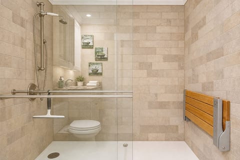 The bathroom features a 24-inch accessible entry and is equipped with a wall-mounted shower chair for added comfort and convenience.