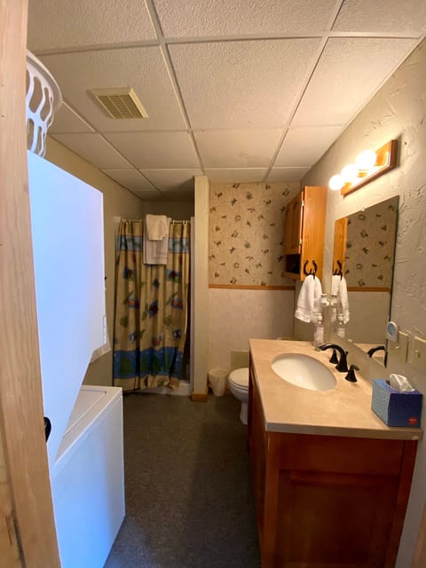Bathroom with shower and stackable washer and dryer unit.