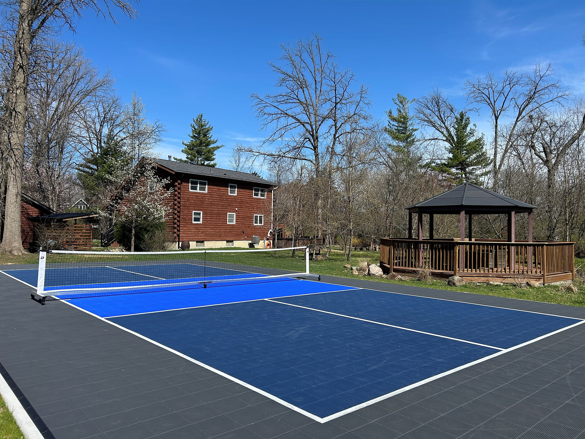 Private onsite regulation size pickleball court with Sport Court surface.