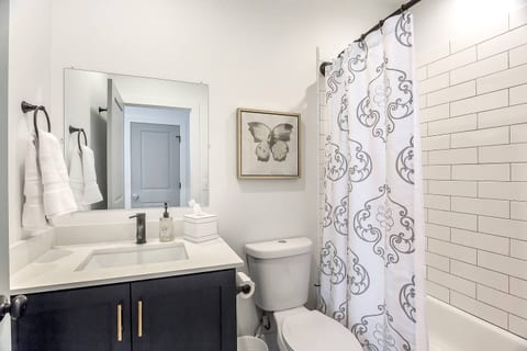 Clean, modern bathroom with subway-tile shower, fresh linens, and stylish finishes. Bright, functional, and well-appointed—perfect for refreshing after a day exploring the city or unwinding in comfort.
