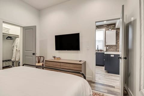 Bright, modern bedroom with a plush king bed, crisp linens, and calming décor. Features a smart TV, ample storage, and a spa-like ensuite feel—perfect for relaxing after a day of work or exploring the city.