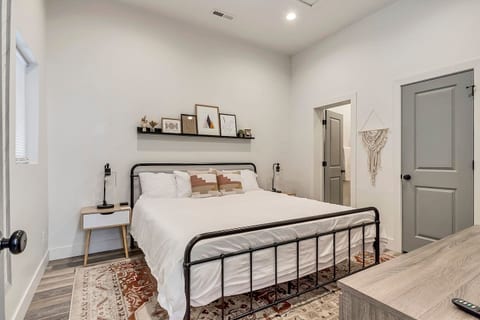 Bright, modern bedroom with a plush king bed, crisp linens, and calming décor. Features a smart TV, ample storage, and a spa-like ensuite feel—perfect for relaxing after a day of work or exploring the city.