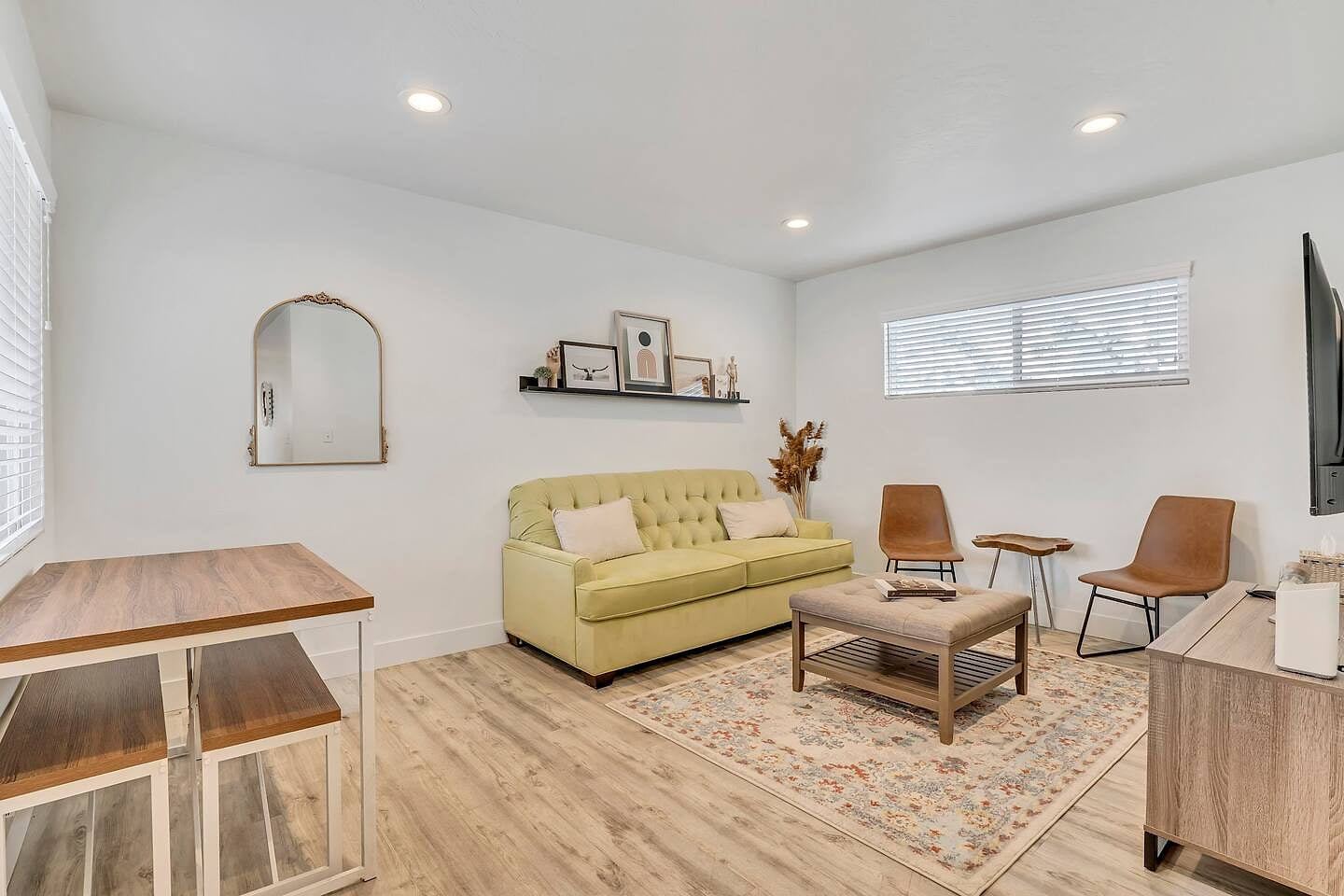 Bright, modern living space with a cozy sofa, smart TV, and tasteful decor. This open-concept lounge offers natural light, comfortable seating, a dining nook, and a calm minimalist vibe—perfect for relaxing, remote work, or unwinding after a day out.