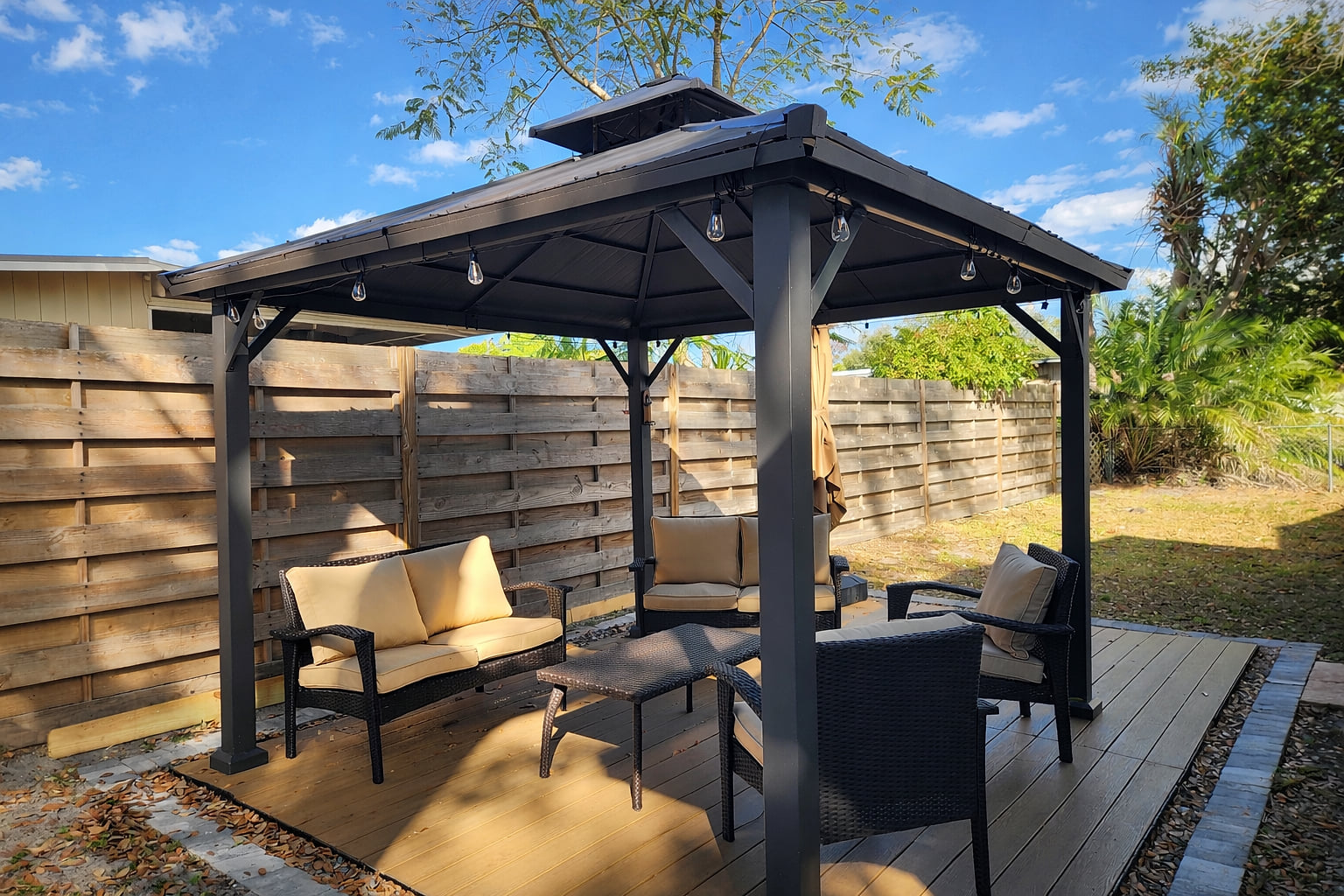 Shaded gazebo lounge with cushioned seating—private backyard retreat.