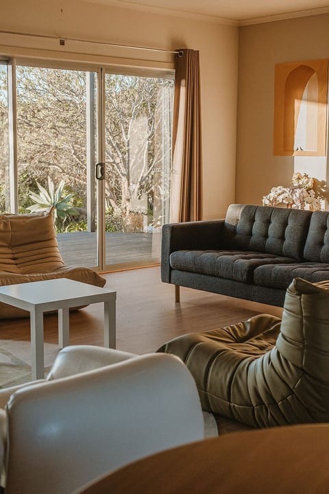 Large living area with a spacious and comfortable couch with the addition of 3 uniquely designed chairs