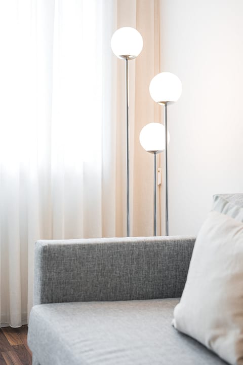 Bright, minimalist lounge with chic globe lamp and cozy sofa
