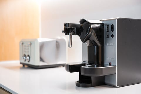 Modern kitchen with espresso maker and toaster—barista-ready mornings.