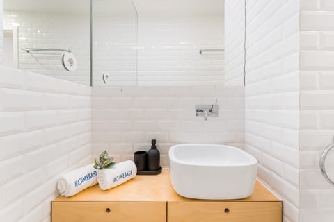 Bright, modern bath with vessel sink, wood vanity and subway tile.