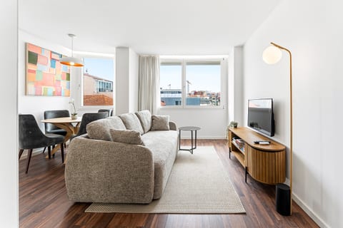 Bright modern lounge with city views, cozy sofa, and stylish dining nook